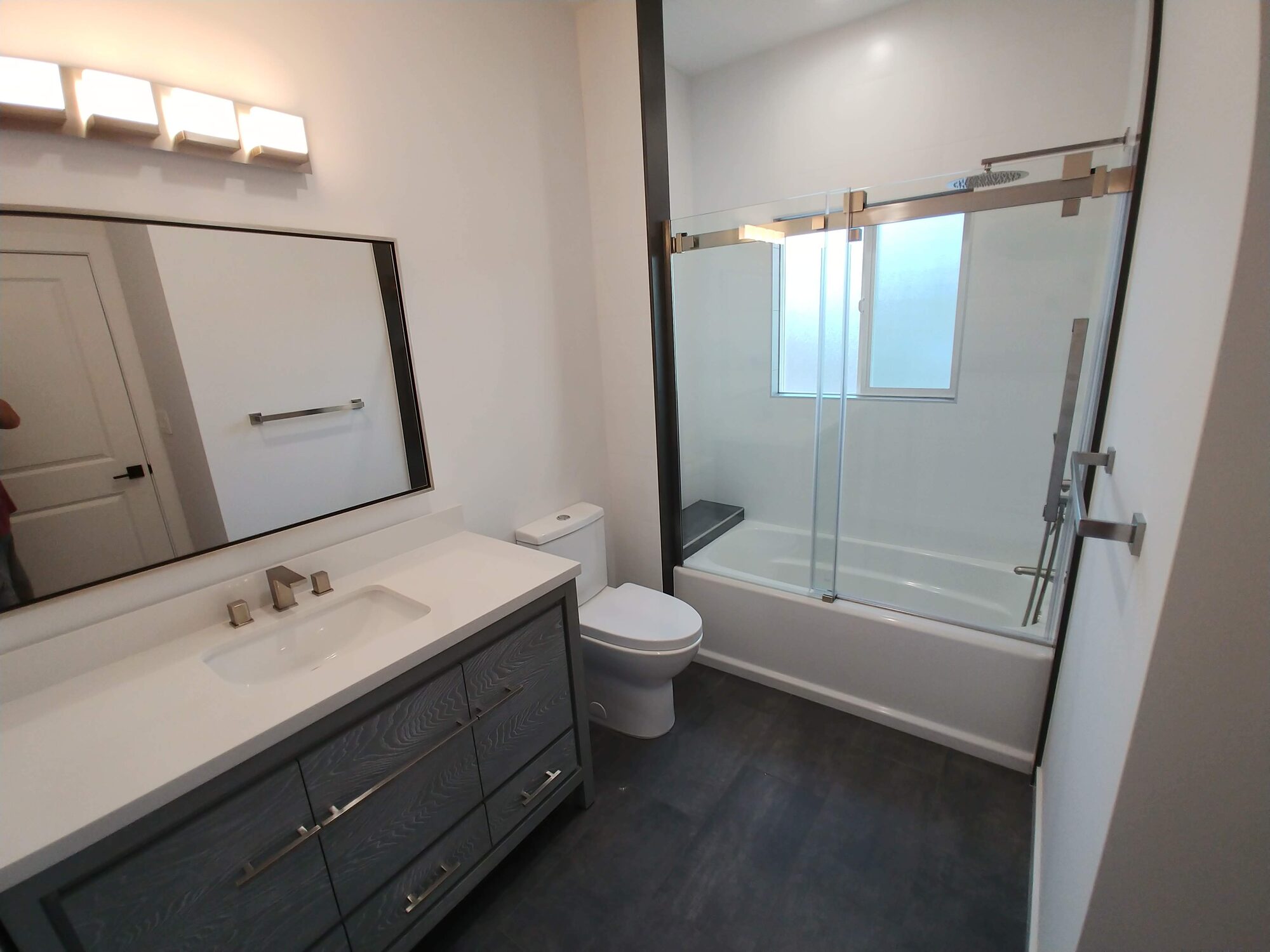 Bathroom with glass shower and grey tile