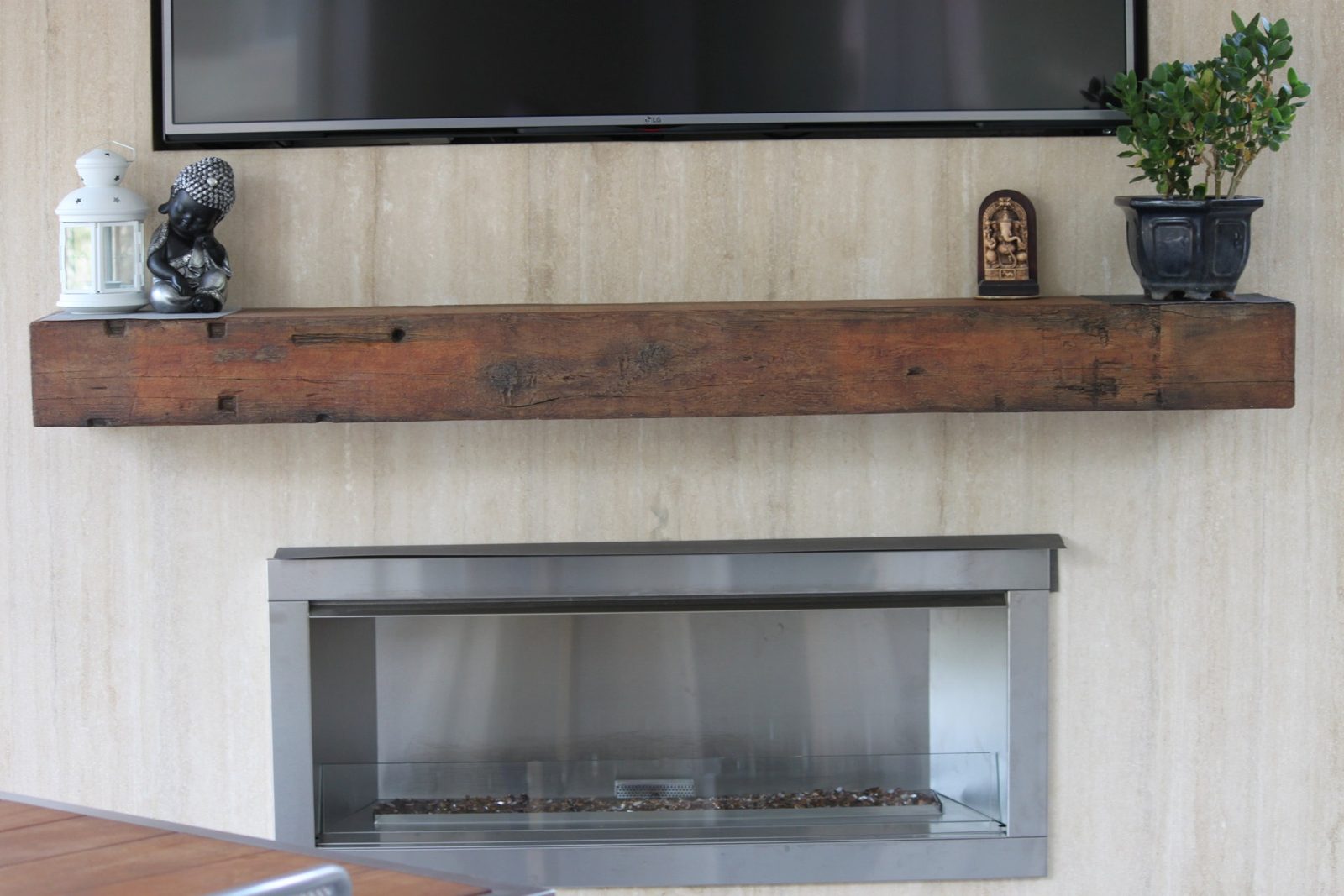 Outdoor fireplace with reclaimed-wood mantel