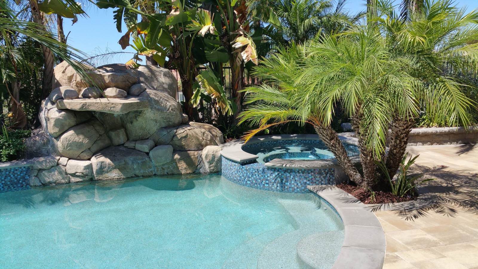 Pool with rock waterfall and spa