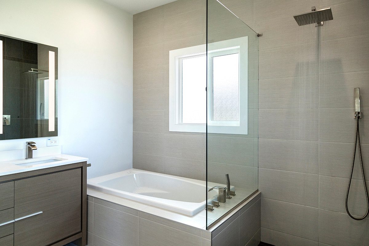 Glass-enclosed soaking tub and shower